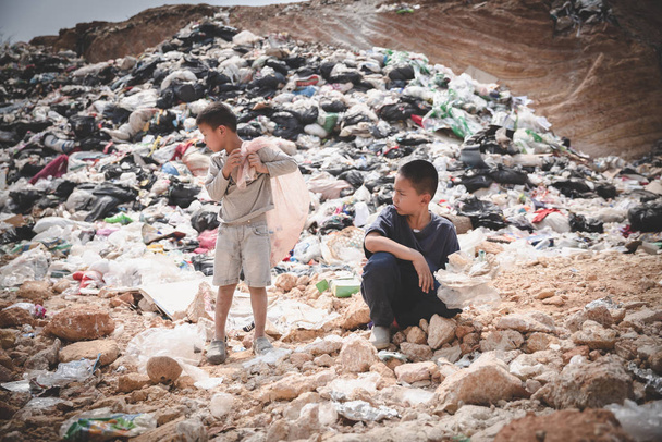 A poor boy collecting garbage waste from a landfill site in the  - Photo, Image