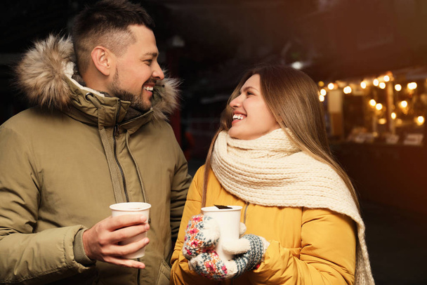 Happy couple with mulled wine at winter fair - Foto, imagen