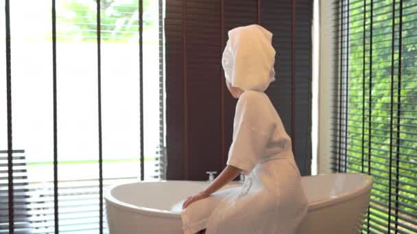 πλάνα από όμορφη Ασιάτισσα γυναίκα που κάνει μπάνιο με σαπουνόφουσκες - Πλάνα, βίντεο