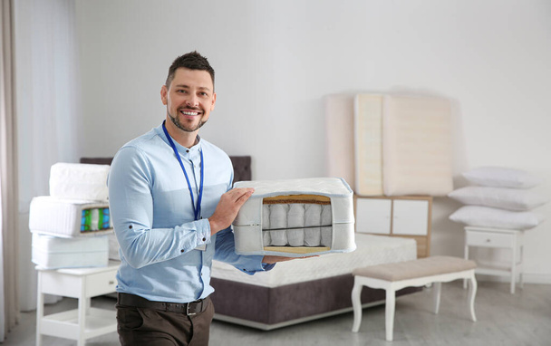 Salesman with section of mattress in furniture store - Φωτογραφία, εικόνα
