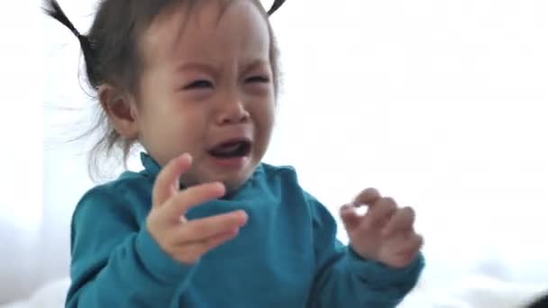 Asijská dívka pláče a dělá povyk. Když je malé dítě ospalé, pláč je znamením, že musí být odneseno do postele. - Záběry, video