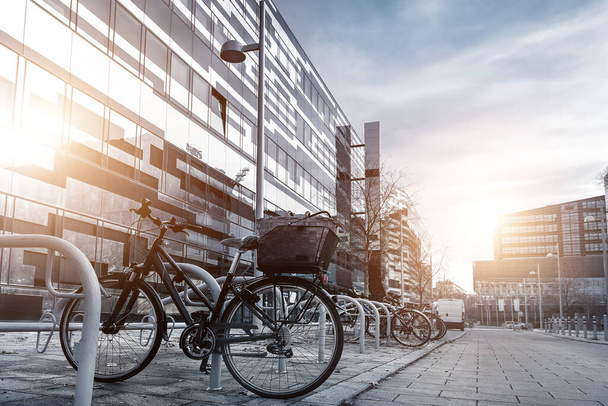 Bicicleta estacionada perto de apartamento moderno cemitério residencial ou campus universitário no centro da cidade europeia de rua. Transporte ecológico e conceito de estilo de vida ativo saudável. Comutação do trabalho sustentável
 - Foto, Imagem