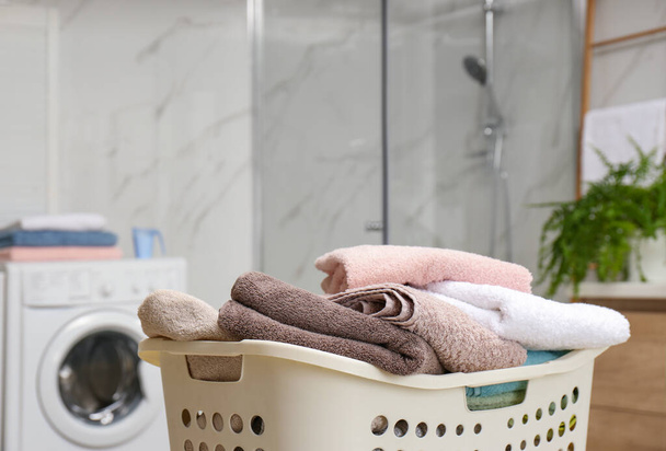 Laundry basket with towels in bathroom, closeup - Foto, afbeelding