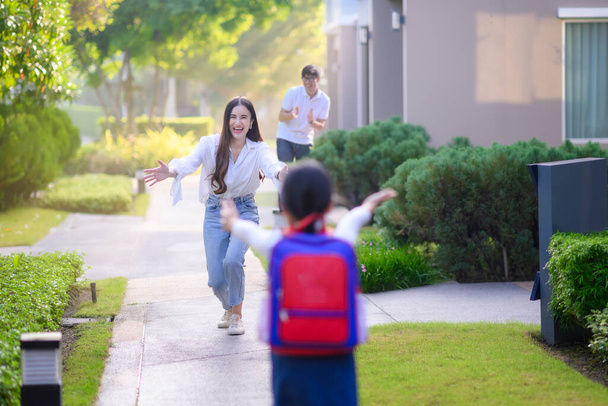 Mom mother and father in motion of happy by opening arm welcome home of daughter, girl daughter exciting in returns home after school study - Foto, Imagen