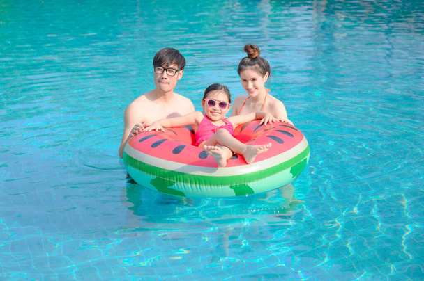 Сім'я насолоджується і щаслива в басейні в літній час, відчувати комфорт і розслаблятися разом
 - Фото, зображення