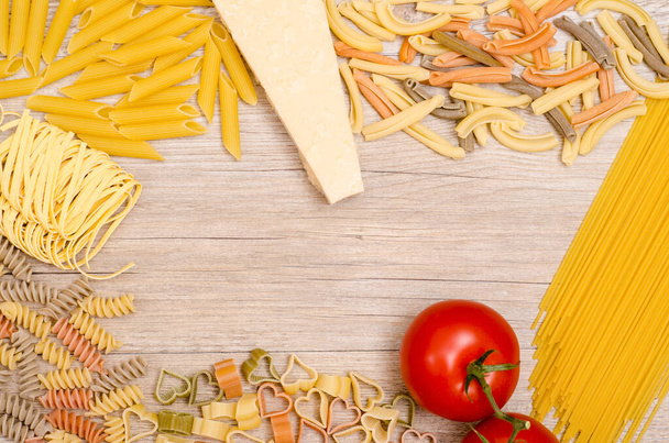various pasta with tomato and parmesan on a wooden board - Foto, afbeelding
