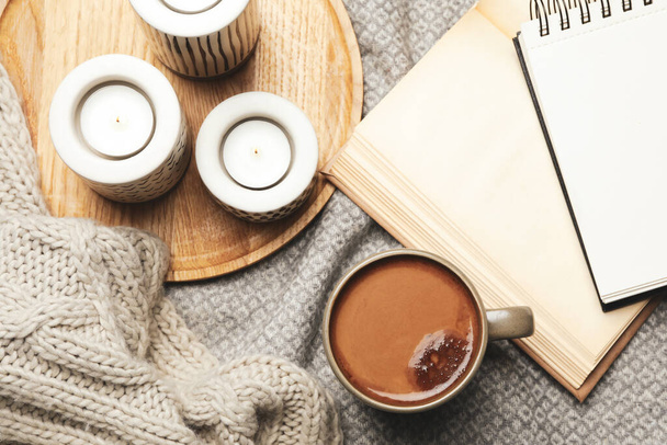 Cup of delicious hot winter drink and candles on grey fabric, flat lay. Winter drink - Φωτογραφία, εικόνα