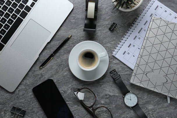 Flat lay composition with laptop, smartphone and stationery on dark grey table - Фото, зображення