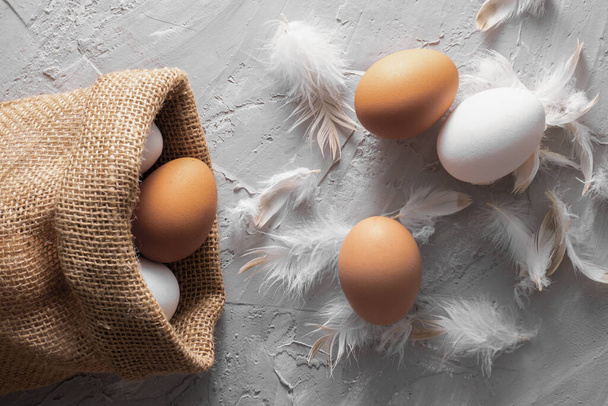 Csirketojás öko-zsákruhában. Barna és fehér rusztikus csirke bolyhos, felső nézet élelmiszer - Fotó, kép