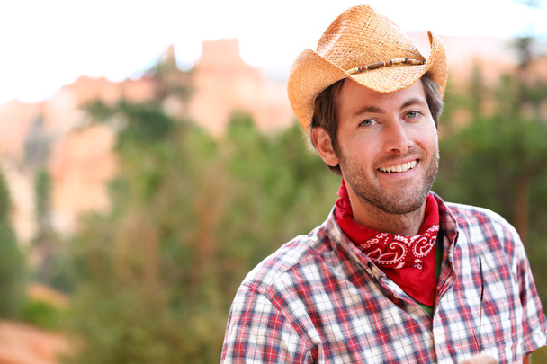 Cowboy man smiling happy wearing hat in country - Foto, afbeelding
