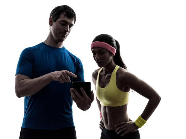 yksi nainen käyttää kunto harjoitus mies valmentaja käyttäen digitaalinen tabletti siluetti valkoisella pohjalla
 - Valokuva, kuva