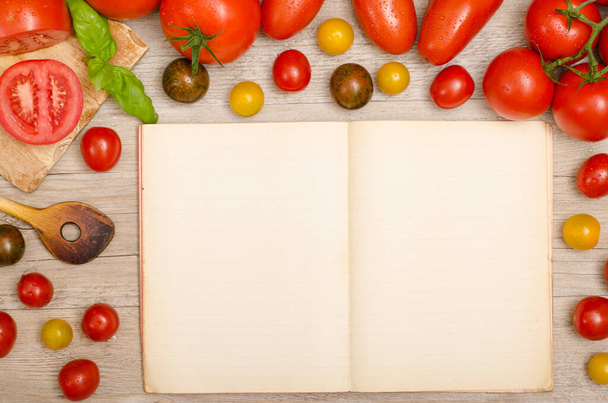 frame wet tomatoes with wooden spoon and copy space in a cookbook - 写真・画像