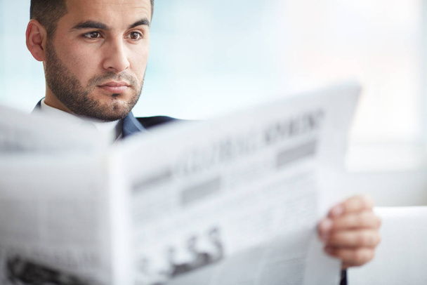 A young serious businessman reading newspaper - Fotoğraf, Görsel