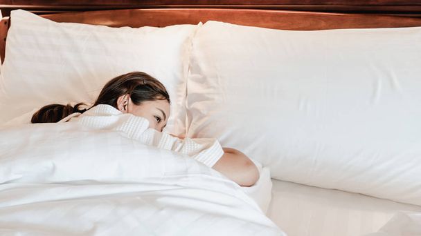 Молода красива жінка прокидається в ліжку після сну добре минулої ночі
 - Фото, зображення