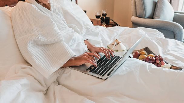 Picture of tourists used laptop and eating fruits on the bed, health food concept - Photo, Image