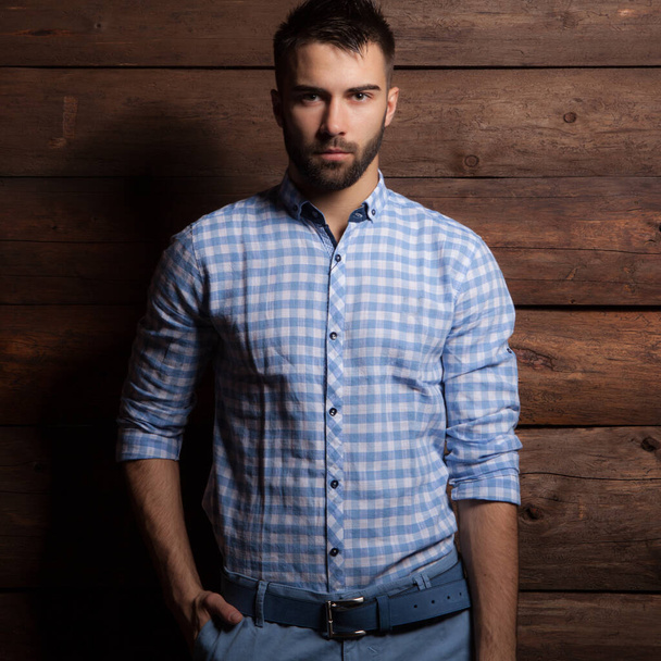 Portrait of handsome young man on wooden background. - Foto, imagen