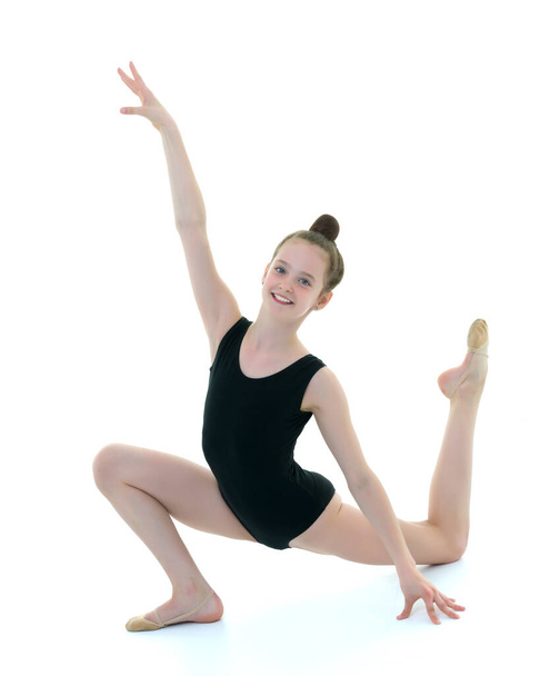 The little gymnast perform an acrobatic element on the floor. - Фото, зображення