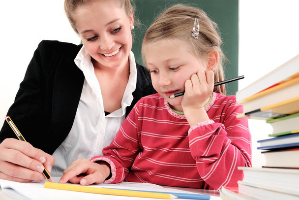 two girls writing in a classroom - Zdjęcie, obraz