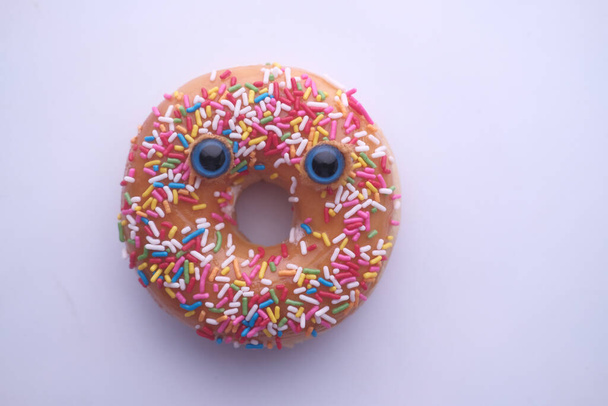 Nahaufnahme von Donut mit lustigem Gesicht auf weißem Hintergrund  - Foto, Bild