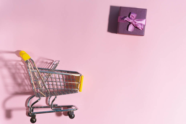 Carrello della spesa e confezione regalo. Comprare regali concetto, shopping online. copia spazio
 - Foto, immagini