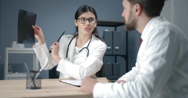 Médicos discutindo raio-X no escritório
 - Filmagem, Vídeo