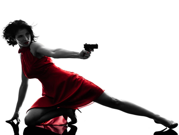 one sexy caucasian woman holding gun in silhouette studio isolated on white background - Foto, Imagem