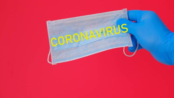 Hand holding a medical mask with the inscription coronavirus - Фото, изображение