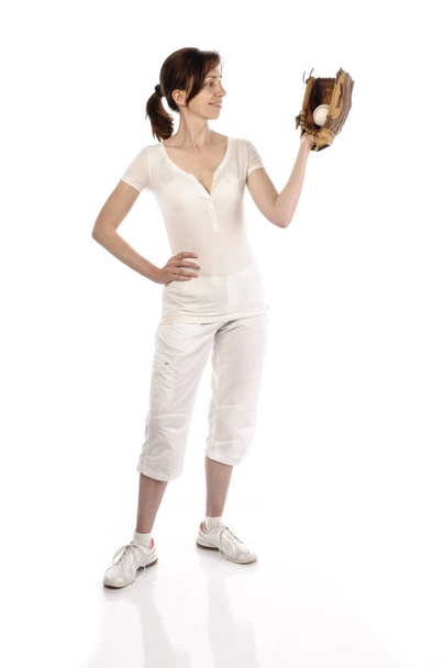 adult woman with baseball glove and white sportswear in front of white background - 写真・画像