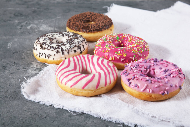 Запеченные сладкие вкусные пончики с хлебными крошками на сером бетонном фоне. Текстура продуктов питания - Фото, изображение