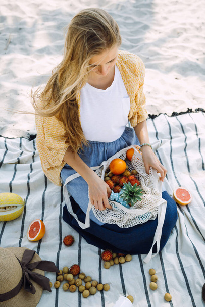 Woman with a cotton string bag and  various exotic fruits - Valokuva, kuva