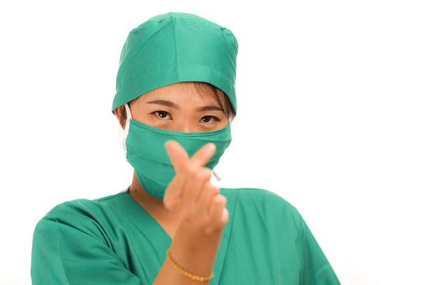 young beautiful and happy Asian Chinese medicine doctor woman or hospital nurse in medical hat face mask and scrub doing fingers love sign smiling cheerful - Photo, Image