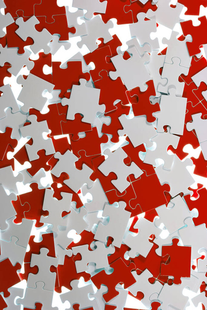white and colored puzzle pieces are mixed up. - Foto, Bild