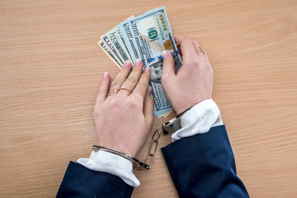 Female hands in handcuffs with dollar - Photo, Image