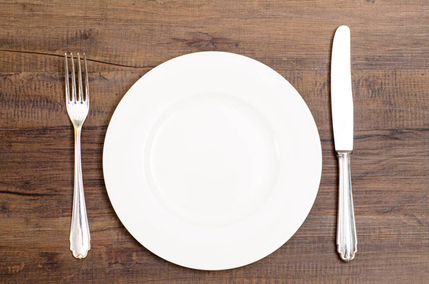 white plate with knife and fork at the inn - Photo, image