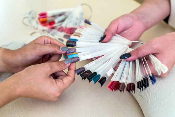 Female hands and colorful nail polish palette - Фото, зображення
