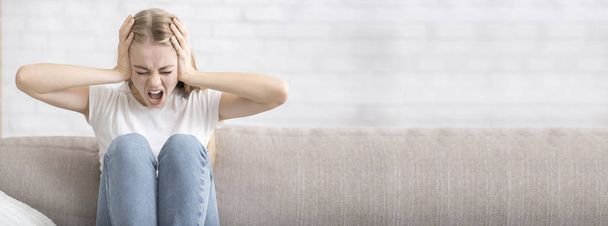 Vyčerpaná dívka zakrývající uši a křik, domácí interiér - Fotografie, Obrázek