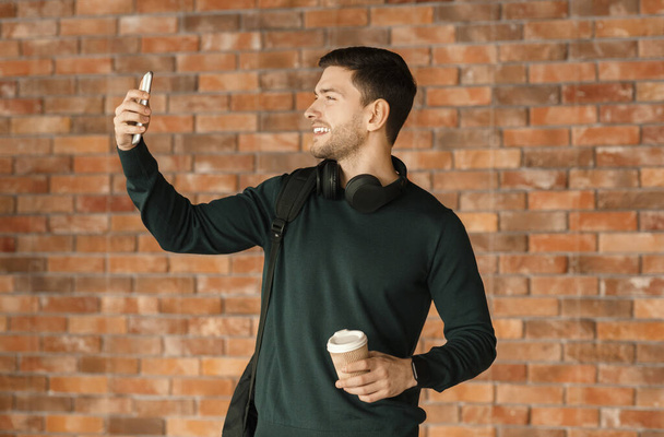 Smartphone 'da Selfie Yapan Adam Tuğla Duvarın Üzerinde Duruyor - Fotoğraf, Görsel