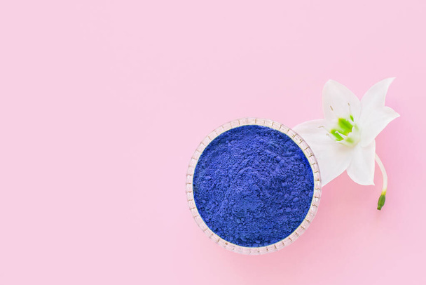 matcha droge blu poeder op een roze achtergrond voor het maken van Japanse natuurlijke thee. - Foto, afbeelding