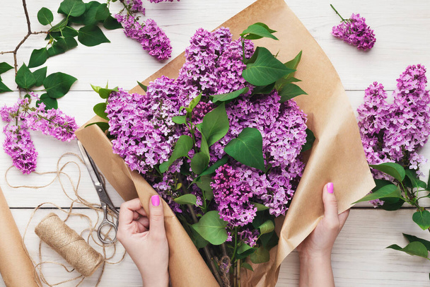 Disposizione bouquet di fiori lilla, fiorista al lavoro
 - Foto, immagini