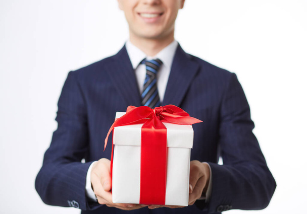 Image of giftbox held by smiling businessman - Foto, afbeelding