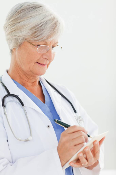 Close up of doctor filling in prescription - Фото, зображення