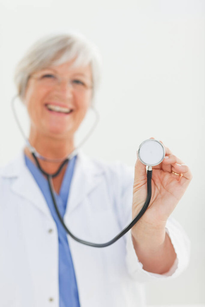 Stethoscope being used by smiling doctor - Foto, Imagen