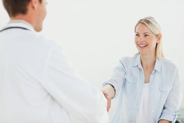 Smiling woman shaking her doctors hand - Foto, Imagen