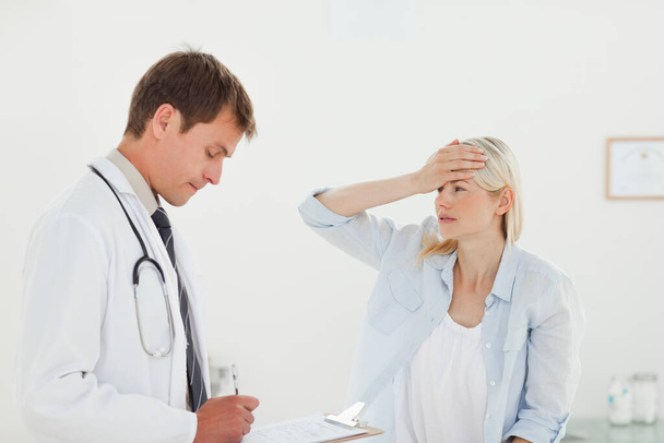 Woman telling her doctor about her headache - Foto, Bild