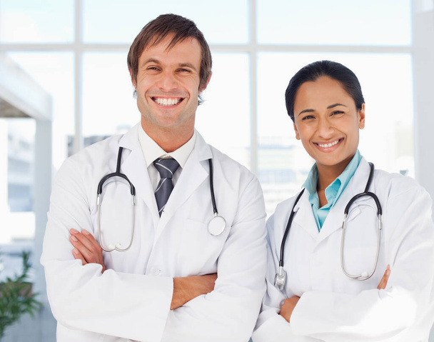 Smiling doctors standing together while looking at the camera - Foto, Imagen