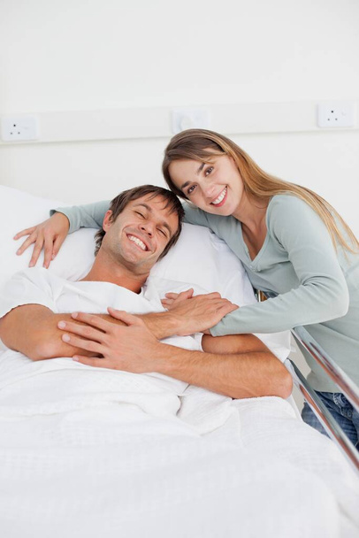 Smiling couple hugging each other on a hospital bed - Foto, Imagem