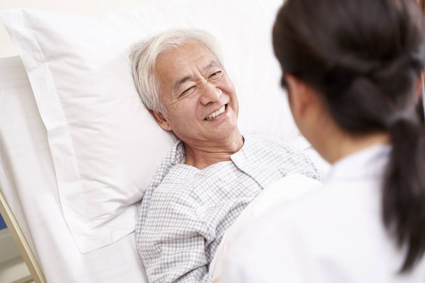 junge asiatische Arzt im Gespräch mit älteren Patienten am Krankenbett in hospt - Foto, Bild