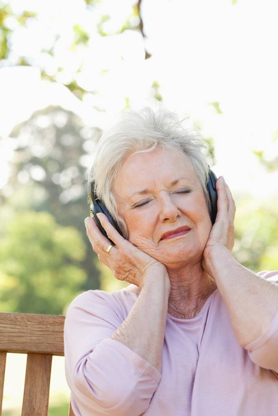 Woman with her eyes closed while listening to music - 写真・画像