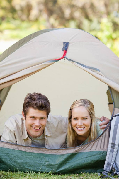 Man and woman camping together and holding each other in the tent - Fotoğraf, Görsel