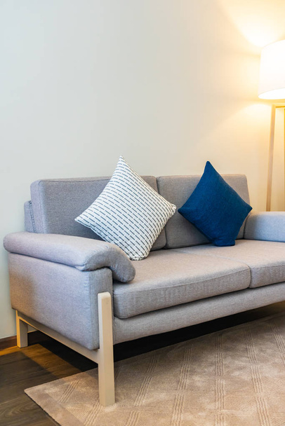 Travesseiro confortável na decoração do sofá com luz interior lâmpada
 - Foto, Imagem